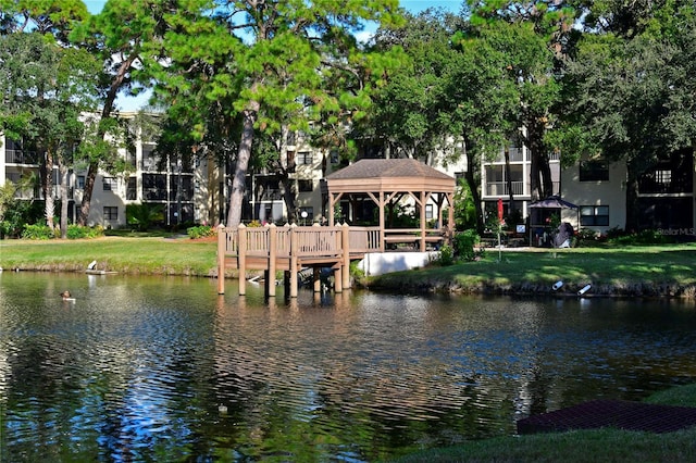 dock area with a gazebo, a lawn, and a water view