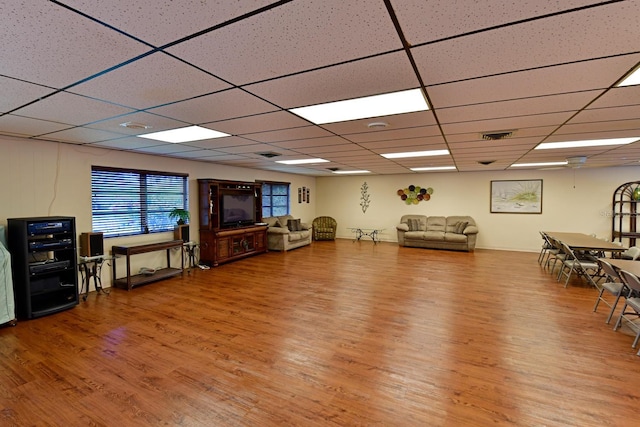 sitting room with a drop ceiling, visible vents, and wood finished floors