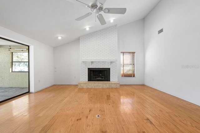 unfurnished living room featuring a wealth of natural light, visible vents, light wood-type flooring, and a fireplace