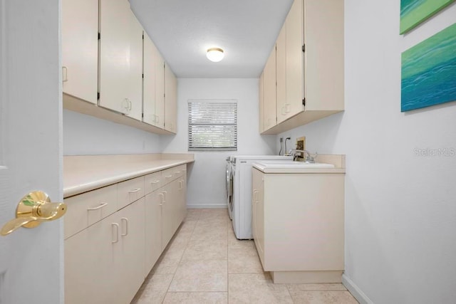 washroom with washing machine and clothes dryer, light tile patterned floors, cabinet space, and baseboards