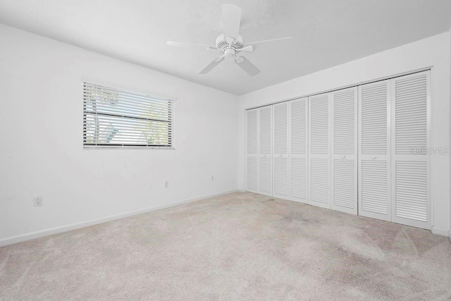 unfurnished bedroom with carpet, baseboards, a closet, and ceiling fan