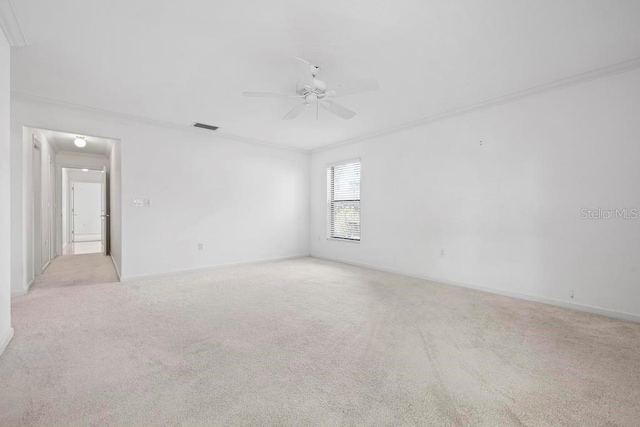 unfurnished room with visible vents, ornamental molding, a ceiling fan, carpet, and baseboards