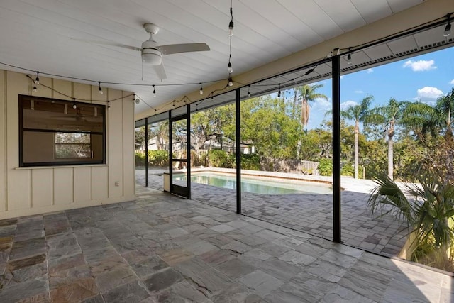 unfurnished sunroom featuring plenty of natural light and a ceiling fan