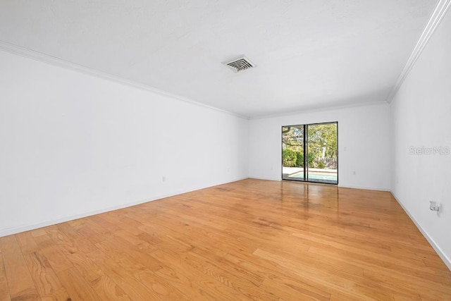 unfurnished room featuring visible vents, light wood-type flooring, baseboards, and ornamental molding