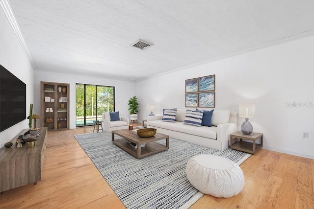 living area with a textured ceiling, wood finished floors, visible vents, and ornamental molding