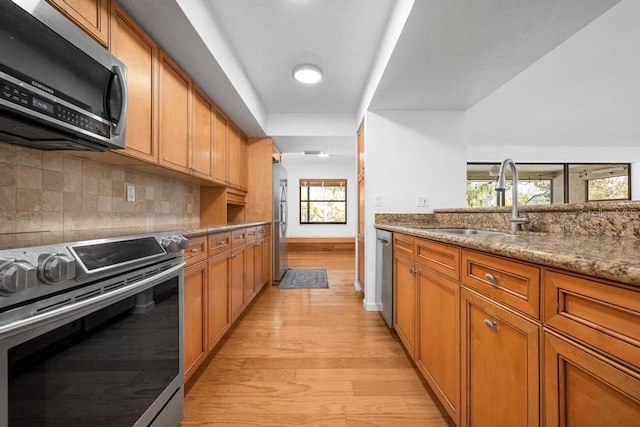 kitchen featuring a sink, stainless steel appliances, and brown cabinets