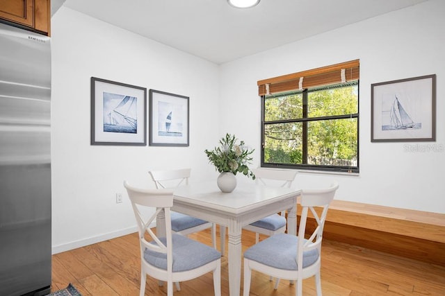 dining room with light wood-style flooring and baseboards