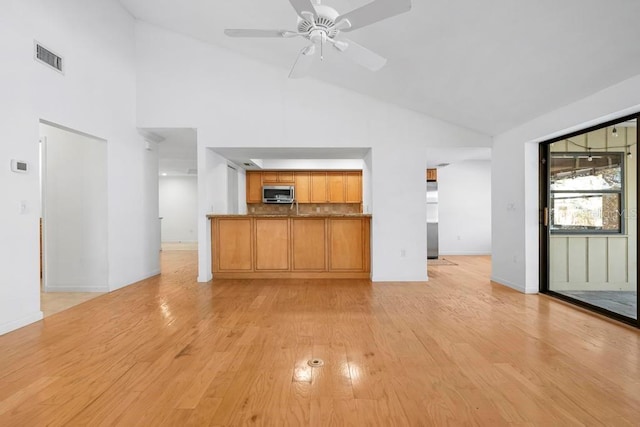 unfurnished living room featuring visible vents, high vaulted ceiling, light wood-type flooring, and ceiling fan