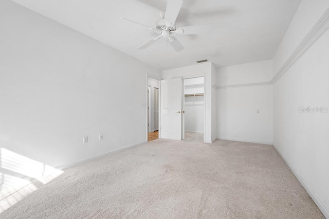 unfurnished bedroom featuring visible vents, light carpet, a closet, baseboards, and ceiling fan