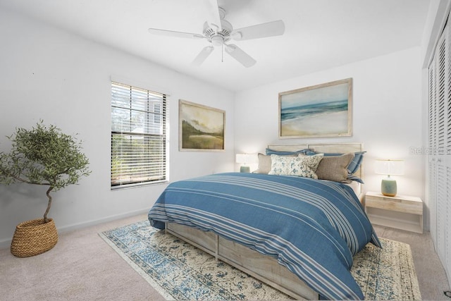 bedroom featuring a closet, baseboards, carpet, and a ceiling fan