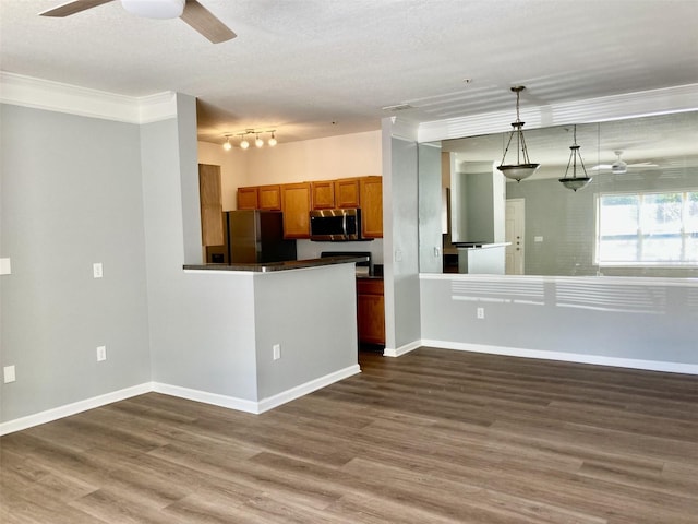 kitchen with dark wood-style floors, dark countertops, brown cabinetry, stainless steel microwave, and black refrigerator with ice dispenser