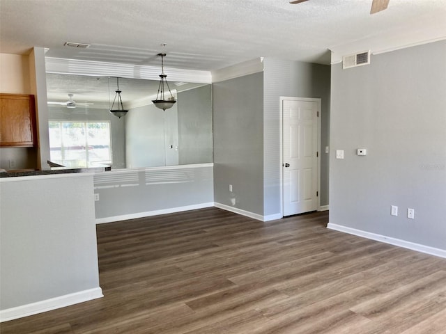 unfurnished room featuring wood finished floors, baseboards, visible vents, ceiling fan, and a textured ceiling