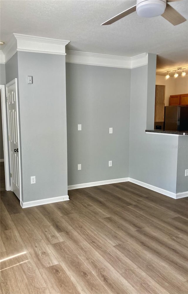 spare room with ornamental molding, wood finished floors, and ceiling fan