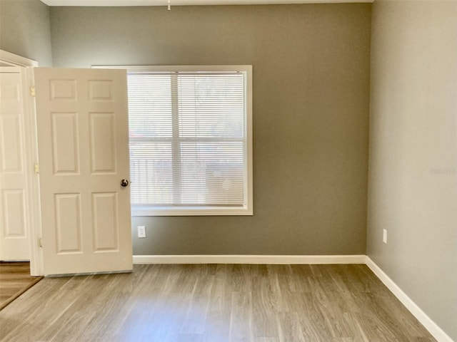 unfurnished room featuring wood finished floors and baseboards