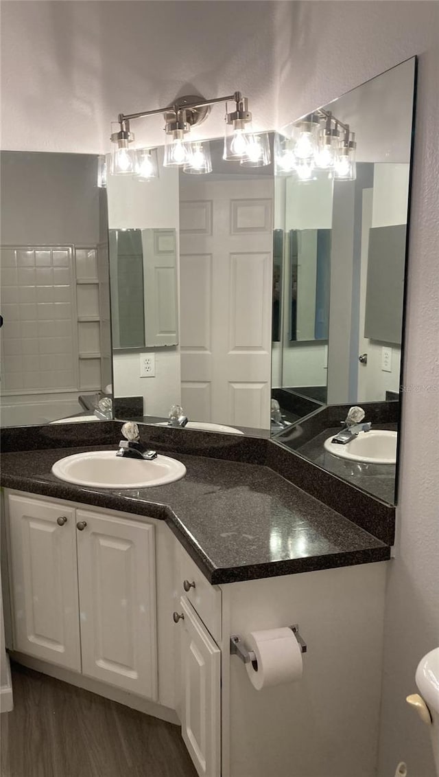 bathroom featuring toilet, wood finished floors, and vanity