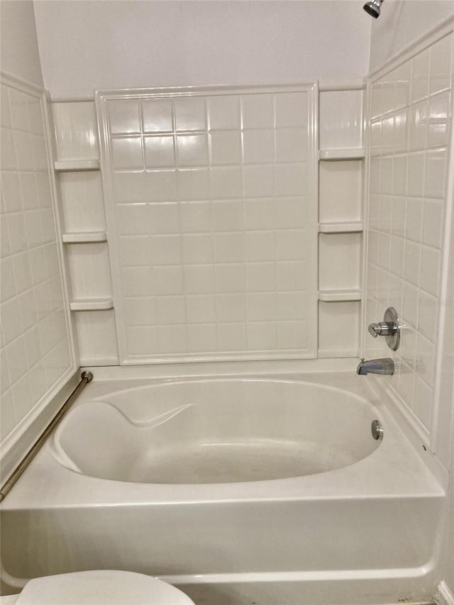 bathroom with tub / shower combination and toilet