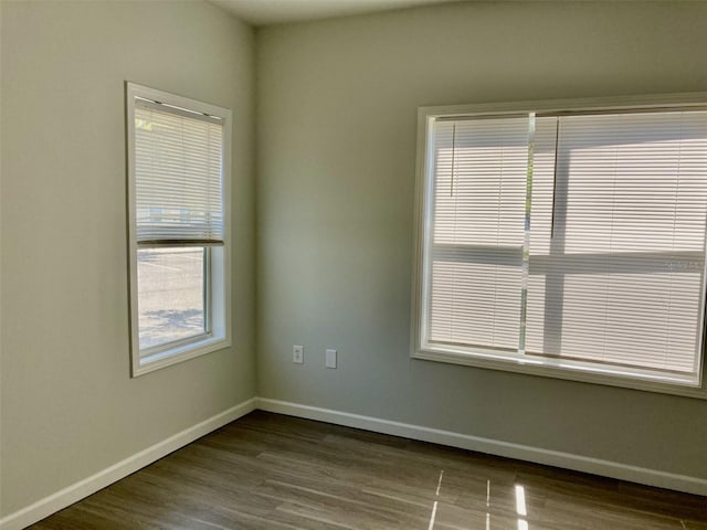 empty room with dark wood-style floors and baseboards