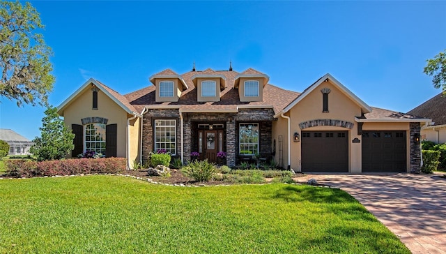 view of front of property with a garage, a front yard, driveway, and stucco siding