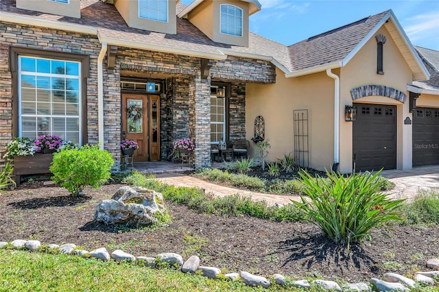 view of front facade featuring stone siding, stucco siding, an attached garage, and covered porch