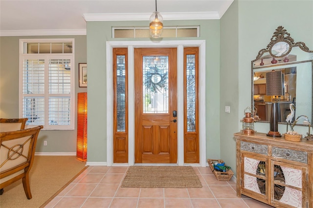 entryway featuring baseboards, ornamental molding, and light tile patterned flooring