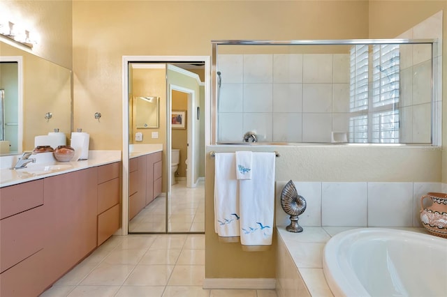 full bathroom with a garden tub, toilet, a stall shower, tile patterned flooring, and vanity