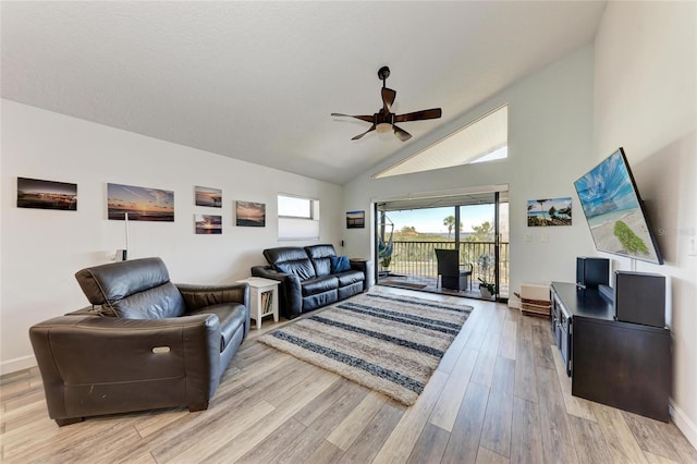 living room with baseboards, high vaulted ceiling, ceiling fan, and light wood finished floors