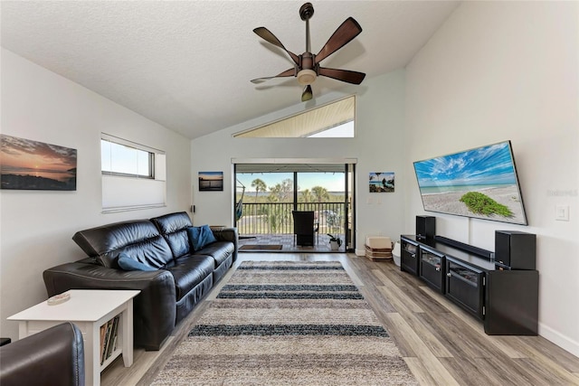 living area with a textured ceiling, light wood-type flooring, a wealth of natural light, and ceiling fan