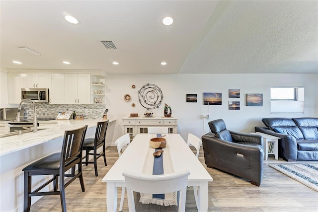 dining space featuring recessed lighting, light wood-style flooring, and visible vents