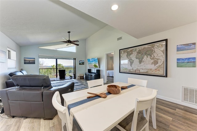 dining space featuring lofted ceiling, wood finished floors, visible vents, and ceiling fan