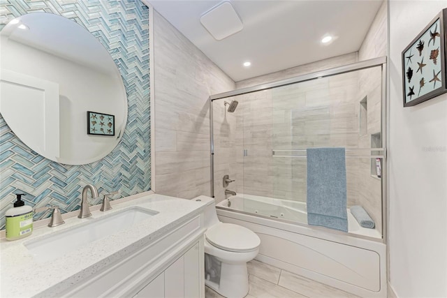 full bath with toilet, vanity, decorative backsplash, combined bath / shower with glass door, and tile walls