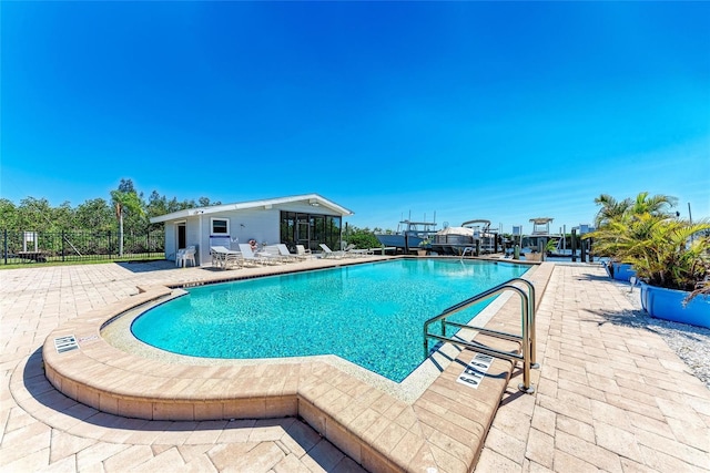 community pool with fence and a patio area