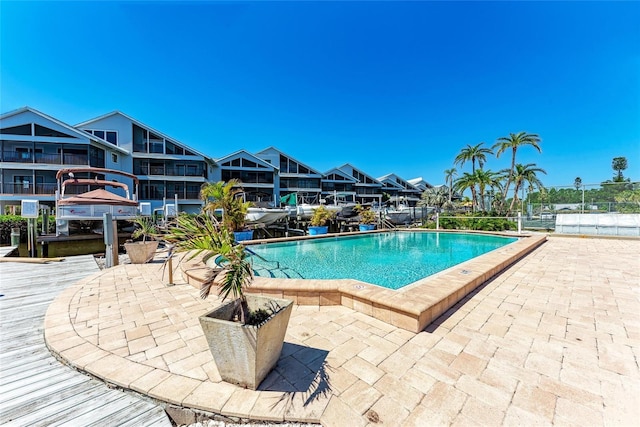 community pool featuring a boat dock and a patio