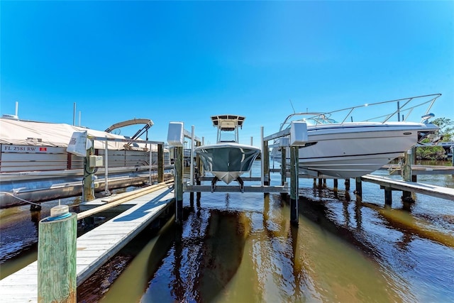 dock area with a water view and boat lift