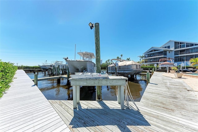 dock area featuring boat lift and a water view