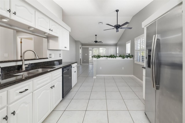 kitchen featuring a sink, stainless steel fridge, light tile patterned floors, dishwasher, and vaulted ceiling