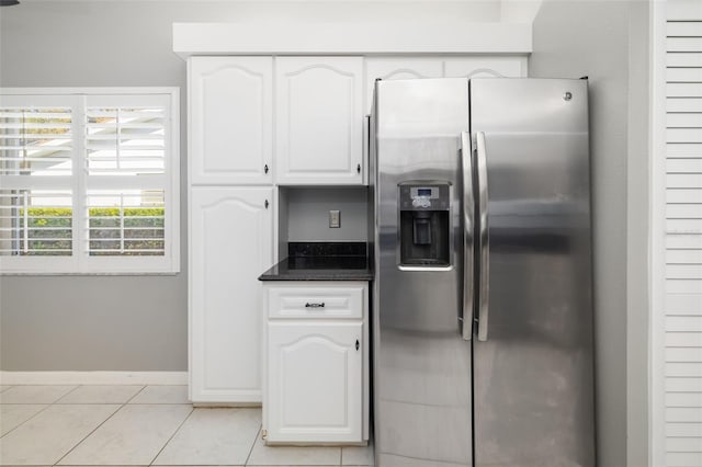 kitchen with white cabinetry, light tile patterned floors, baseboards, and stainless steel fridge