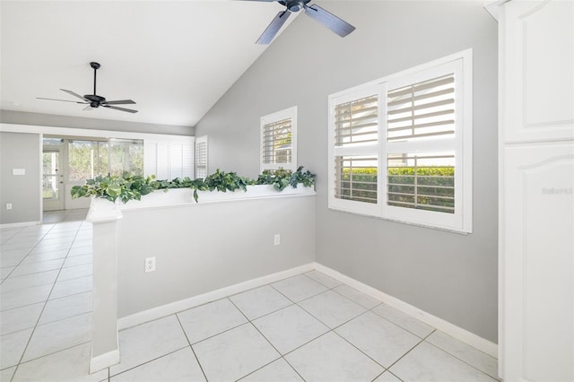 spare room with light tile patterned floors, baseboards, ceiling fan, and vaulted ceiling