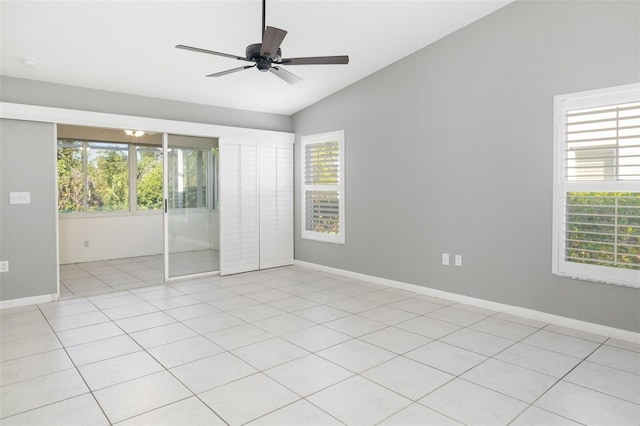 unfurnished bedroom with lofted ceiling, light tile patterned floors, a ceiling fan, and baseboards