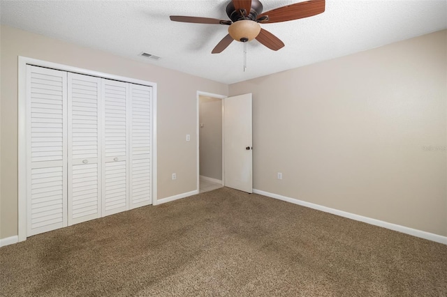 unfurnished bedroom featuring carpet flooring, visible vents, a closet, and a textured ceiling