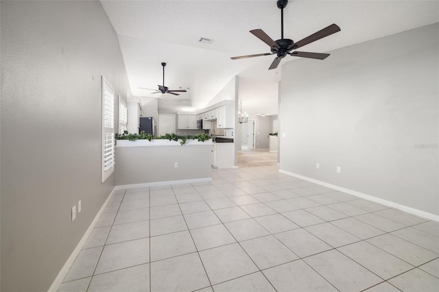 empty room with visible vents, ceiling fan, high vaulted ceiling, and baseboards