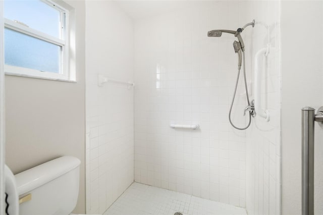 full bathroom featuring toilet and tiled shower