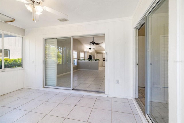 unfurnished sunroom with a ceiling fan and visible vents