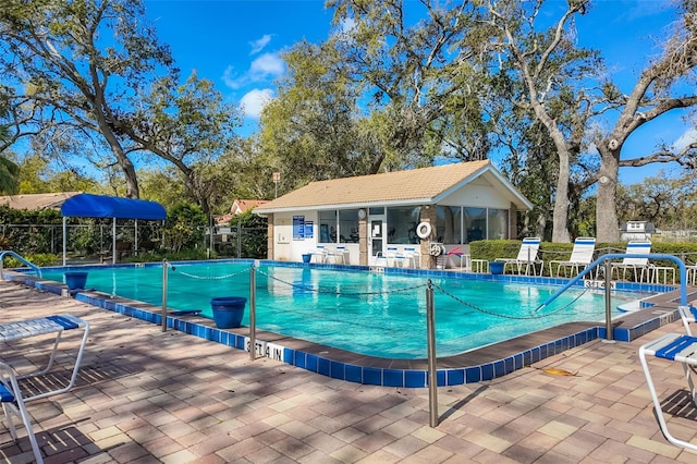 community pool with a patio and fence