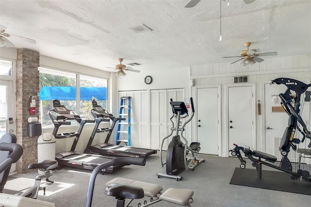 gym with a wealth of natural light, visible vents, and a textured ceiling