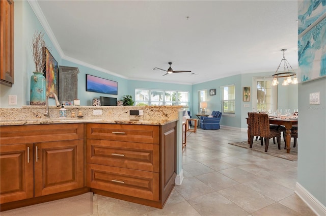 kitchen with open floor plan, brown cabinets, a peninsula, and ornamental molding