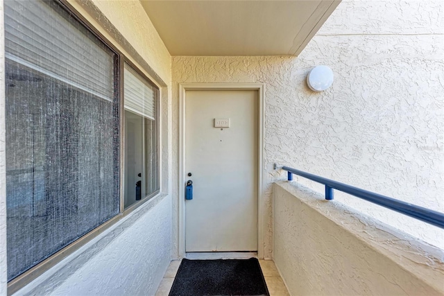 doorway to property featuring stucco siding