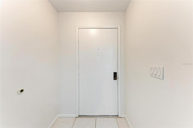 doorway to outside with baseboards and light tile patterned flooring