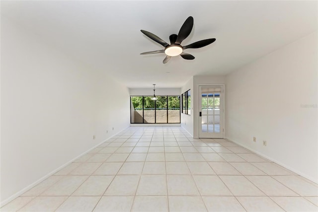 unfurnished room with light tile patterned floors, a ceiling fan, and baseboards