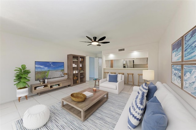 living room featuring ceiling fan, visible vents, and light tile patterned flooring