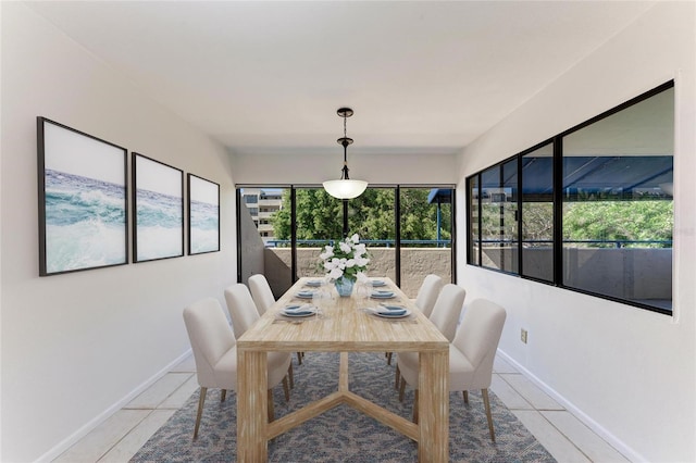 dining space featuring light tile patterned flooring and baseboards